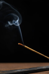 Smoke from a burning aroma stick on a black background. Incense sticks, aromatherapy and meditation.
