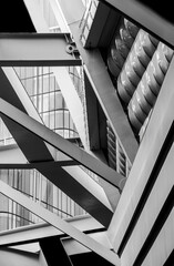Geometric abstraction of straight metal beams, glass surfaces located at different angles. Black and white photo