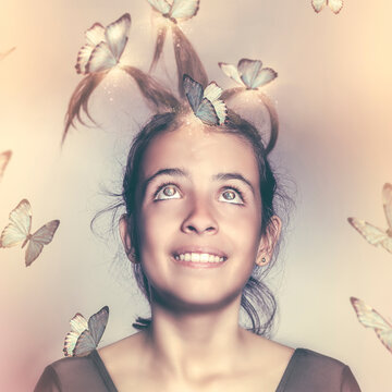 Portrait of a beautiful girl surrounded by flying butterflies pulling her hair