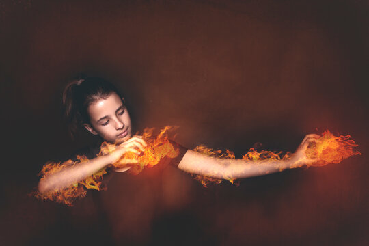 Portrait of a teenage girl doing a magic trick setting her arms on fire