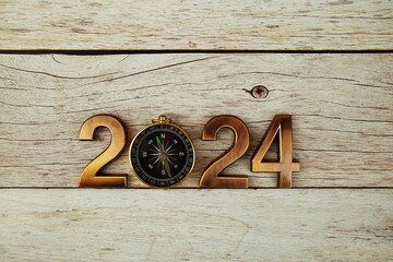 Happy New Year 2024 alphabet letters with compass on wooden background, new year goal and...