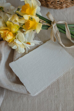 Overhead view of a bunch of daffodils with a blank card on a table
