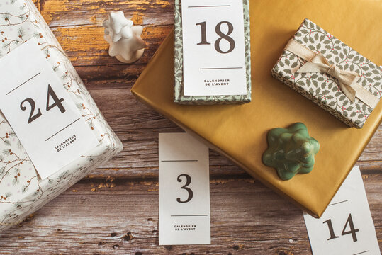 Overhead view of gifts for an advent calendar next to Christmas decorations