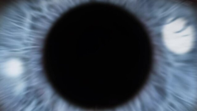 Macro Shot of Eye Pupil Opening with Beautiful Blue Iris. Zoom in to an Infinite Black Background and Zoom out to Macro Close up. Healthy Eyesight concept. 