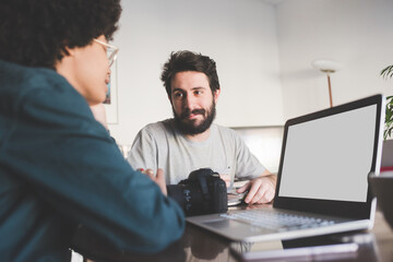 Young multiethnic couple remote working at home using computer