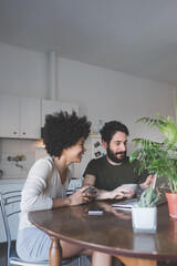 young multiethnic couple indoor watching streaming on computer having coffee