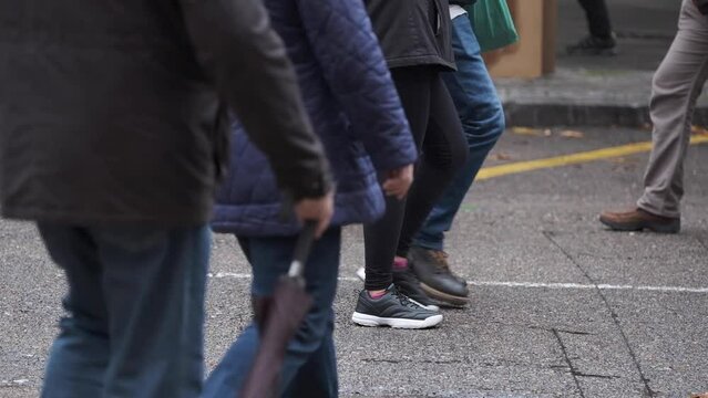 detail of the feet and shoes of a group of people while walking