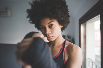 young multiethnic woman indoor training boxe at home
