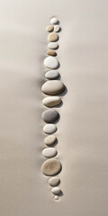 Zen Harmony: Pebbles Arranged in a Line on a Sandy Beach