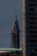 Rijeka cityscape. Modern buildings and old church tower with mediterranean sea as background.