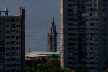 Rijeka cityscape. Modern buildings and old church tower with mediterranean sea as background.