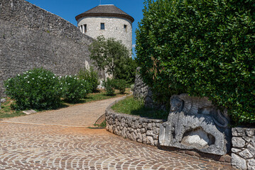 Entrance to Trsat Castle in Rijeka, Croatia. Historical cobblestone street, stone relief and stone walls.