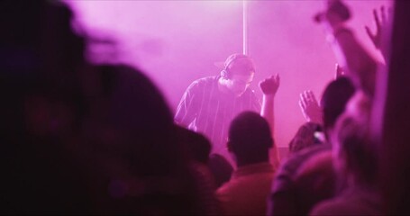 Crowd, dance and nightclub DJ with rave, techno or disco lights for music, party and celebration or festival event. Group of people or audience hands at club for cheers, listening and energy in dark