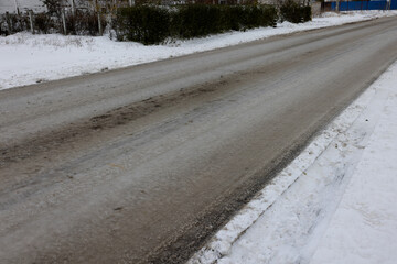 Snowy road in countryside. Drifts on an unplowed snow-covered country road through cottage...