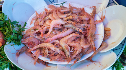 Dish of shrimp at the Essaouira fish market. Fishermen skillfully clean and prepare the catch,...