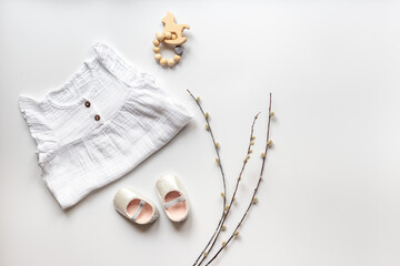 White dress for baby girl with shoes and toys, top view