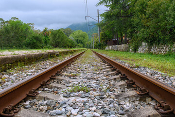 Fototapeta na wymiar Old rusty rails, sleepers close-up. Railway in cloudy autumn weather.