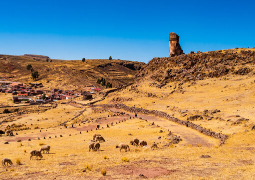 Panoramic view of Sillustani archeological site with its tallest chullpa (funerary tower) and the touristic village in background, Puno region, Peru