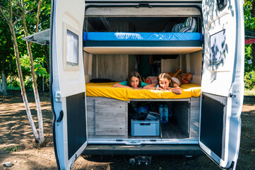 Family waking up in a campervan in the camping campsite.