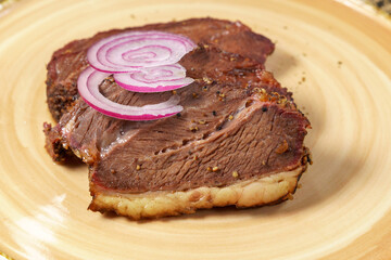 Beef steak close-up with onions. Concept of tasty food. Serving dishes in the restaurant