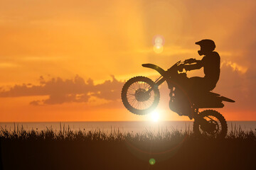 Silhouette of a motocross motorcycle lifting the front wheel. Adventure and Action Concepts