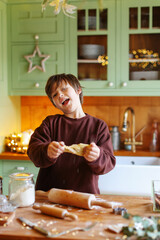 Boy make fun and cook cake for Christmas on kitchen table