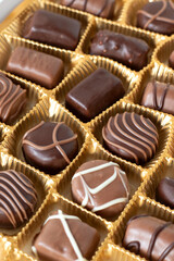Gift box of various praline chocolate candies. Close-up, selective focus.