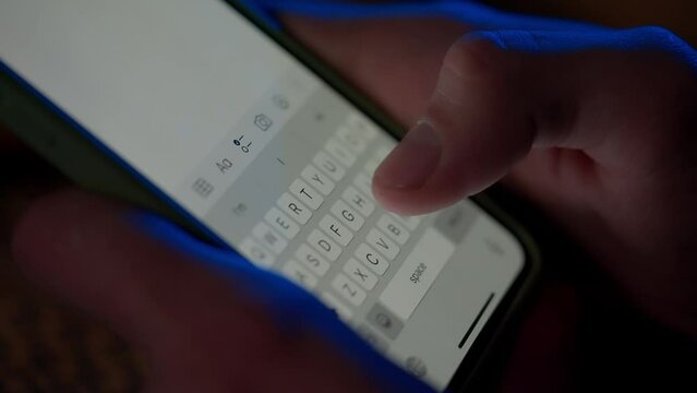 Text message with smartphone. A man sends a message from his phone, turns it off and sets it aside. Digital instant messaging chat. Macro shot of keyboard and finger writing.