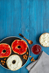 Baked bread bagels with with berry jam and cheese cream. Healthy breakfast background