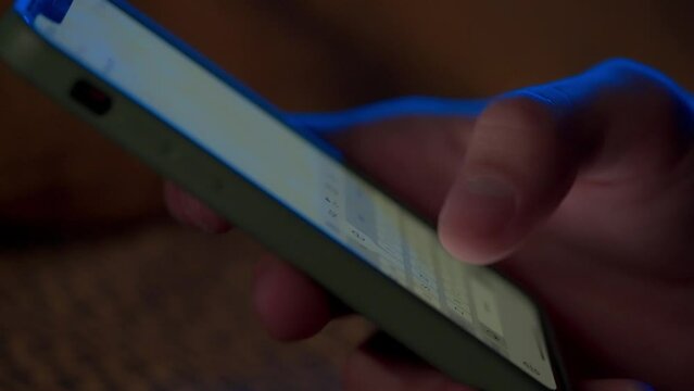 Text message with smartphone. Side view of a smartphone in a man's hand macro shot. A man types a message and turns off the smartphone. Digital instant messaging chat.