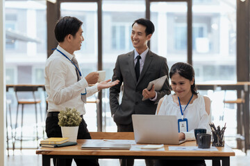 Asian businesspeople having a discussion with his colleague in an office. Asia business people using a laptop in a meeting.