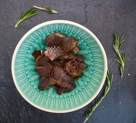 Bowl of dried jerkty with thyme on slate 