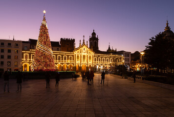 Portuguese Christmas lights decoration with an enormous tree in Braga city center, Portugal. People taking photos with smartphones of the christmas decorations
