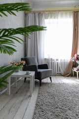 interior in the room coffee table, armchair, decorative flower