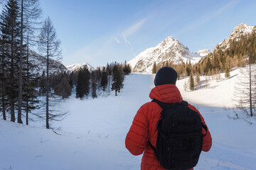 Fototapeta na wymiar Hiker man enjoy the amazing landscape in snowy mountains