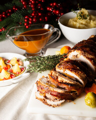 Close-up of cut stuffed turkey with sauce, vegetables and mashed potatoes, Christmas decoration, vertical