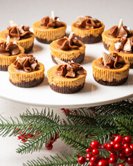 Top view of chocolate and coffee cakes with wafer on plate and white table, Christmas decorations, selective focus, vertical