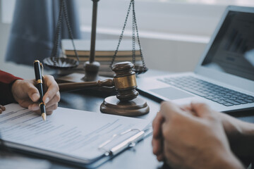 Justice and law concept.Male judge in a courtroom with the gavel, working with, computer and...