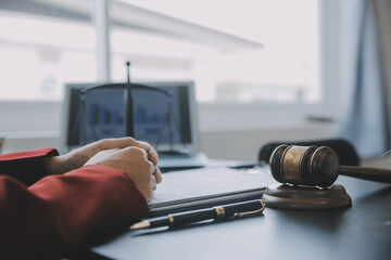 Justice and law concept.Male judge in a courtroom with the gavel, working with, computer and...