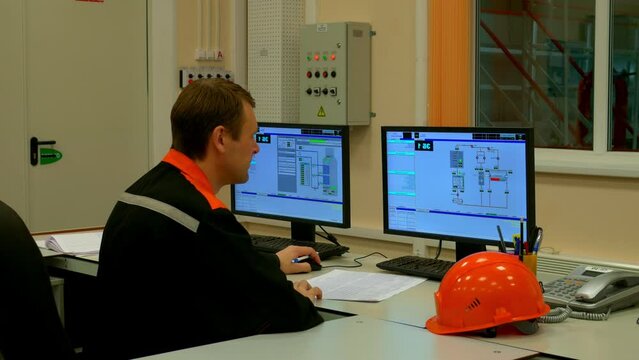 Industrial operator at plant checks machinery, ensuring industry standards. Focused on industry norms, operator oversees equipment with precision. Industry efficiency highlighted in monitoring tasks.