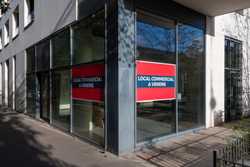 'Local commercial à vendre' écrit en Français sur deux affiches collées sur la fenêtre d'un local professionnel ou commercial. Concept de marché immobilier professionnel en France