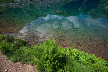 Clear water of Lake Dukka "Rybka" on the Malaya Dukka River on the slopes of the Arkasar ridge in the North Caucasus on a sunny summer day, Arkhyz, Karachay-Cherkessia, Russia © Ula Ulachka