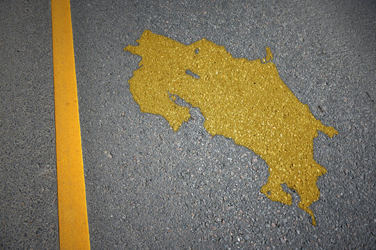 yellow map of costa rica country on asphalt road near yellow line.