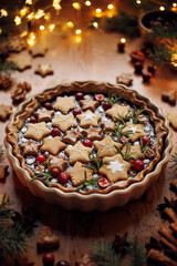 Christmas gingerbread and chocolate tart on a wooden table, close-up view
