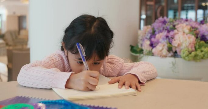 Little girl draw on the book