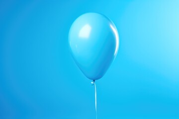 A blue balloon floats in the air against a blue background. This versatile image can be used for various occasions and themes.