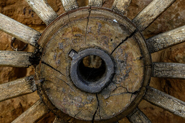 Front view of axle of an old wooden cart wheel, unused, souvenir of old times. Agriculture, history, Europe. Old wooden horse-drawn carts