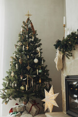 Cozy stockings hanging on mantel and stylish christmas tree in modern farmhouse. Rustic christmas...