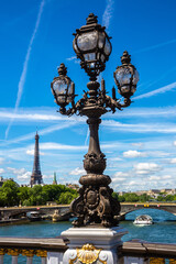 Bronze sculpture on the Bridge Pont Alexandre III and Eiffel Tower in the behind in Paris, France
