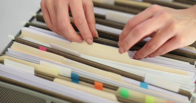 Searching in drawer full of documents closeup